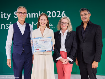 Dr. Sara Schiffer präsentiert lächelnd ihre Auszeichnung als Mobility Trailblazer 2026 auf der Bühne.